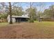 Backyard featuring a screened-in porch, picnic table, and a spacious yard, great for entertaining and relaxation at 749 Cassadaga Rd, Lake Helen, FL 32744