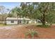 Charming single-story home with a well-maintained lawn, mature trees, and a welcoming entrance at 749 Cassadaga Rd, Lake Helen, FL 32744