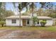 Charming single-story home with palm trees and an inviting front entrance at 749 Cassadaga Rd, Lake Helen, FL 32744