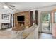Cozy living room featuring a brick fireplace and access to a screened in porch at 749 Cassadaga Rd, Lake Helen, FL 32744