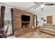 Cozy living room featuring a brick fireplace, ceiling fan, and tile flooring at 749 Cassadaga Rd, Lake Helen, FL 32744