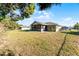 Wide view of the backyard with lush grass and a screened in lanai at 755 Fairlawn Dr, Orange City, FL 32763