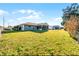 Large backyard with a grey home, screened-in lanai, and plenty of green grass at 755 Fairlawn Dr, Orange City, FL 32763