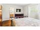 Bedroom features hardwood floors, a large bed, dresser and television, and ensuite bathroom at 755 Fairlawn Dr, Orange City, FL 32763