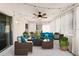 Cozy sunroom with rattan furniture, stylish cushions and curtains and string lights overhead at 755 Fairlawn Dr, Orange City, FL 32763
