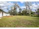 Large, grassy backyard offering a serene and private outdoor space, complemented by mature trees and ample room to play at 818 W Pennsylvania Ave, Deland, FL 32720
