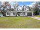 Charming single-story home with white painted brick, black trim, manicured lawn, and a black garage door at 818 W Pennsylvania Ave, Deland, FL 32720