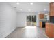 Bright open living space with vinyl floors, shiplap accent wall, sliding glass doors, and modern kitchen at 818 W Pennsylvania Ave, Deland, FL 32720