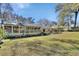 Lush backyard featuring a screened-in porch, a well-manicured lawn, and mature trees at 857 Westchester Dr, Deland, FL 32724