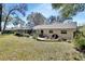 Expansive backyard featuring a charming fire pit, spacious lawn, and ample seating for outdoor enjoyment at 857 Westchester Dr, Deland, FL 32724
