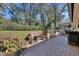 Private backyard featuring lush landscaping, brick patio and cozy firepit seating area at 857 Westchester Dr, Deland, FL 32724