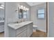 Updated bathroom with a marble countertop, wood look floor, and bright vanity lighting at 857 Westchester Dr, Deland, FL 32724