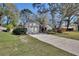 Attractive home exterior with a paved driveway, well-kept lawn, and mature trees, showcasing its curb appeal at 857 Westchester Dr, Deland, FL 32724