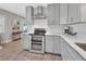 Kitchen with stainless steel appliances, gray cabinets, marble counters, and hardwood floors at 857 Westchester Dr, Deland, FL 32724