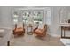 Bright sitting room with hardwood floors, two leather chairs, and bright natural light at 857 Westchester Dr, Deland, FL 32724