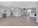 Open-concept living space with wood-look tile, chandelier, and adjacent bar with white cabinets at 857 Westchester Dr, Deland, FL 32724