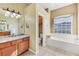 Bathroom featuring a soaking tub, a separate toilet room and a double vanity with granite countertop at 9223 Shadow Pinar Ct, Orlando, FL 32825