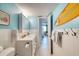 Well-lit bathroom with white vanity, tiled walls, and a surfboard art piece is ready for coastal living at 935 Ocean Shore Blvd # 4010, Ormond Beach, FL 32176