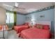 Comfortable bedroom with two beds, ceiling fan, and light blue walls with decorative tropical themed border at 935 Ocean Shore Blvd # 4010, Ormond Beach, FL 32176