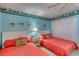 Relaxing bedroom with two beds, ceiling fan, and light blue walls with decorative tropical themed border at 935 Ocean Shore Blvd # 4010, Ormond Beach, FL 32176