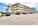 Exterior of the condo building with multiple cars parked in the parking lot on a sunny day at 935 Ocean Shore Blvd # 4010, Ormond Beach, FL 32176