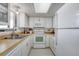 Bright kitchen with white cabinetry, appliances, light countertops, and vinyl flooring at 935 Ocean Shore Blvd # 4010, Ormond Beach, FL 32176