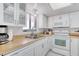 Bright kitchen with white cabinetry, appliances, light countertops, and vinyl flooring at 935 Ocean Shore Blvd # 4010, Ormond Beach, FL 32176