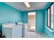 Brightly painted laundry room featuring a washer, dryer, window, and a door at 935 Ocean Shore Blvd # 4010, Ormond Beach, FL 32176