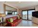 Inviting living room with leather sofa, mirror accent wall, and a sliding door to a balcony with ocean views at 935 Ocean Shore Blvd # 4010, Ormond Beach, FL 32176