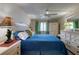 Bright main bedroom with a comfortable bed, ceiling fan, and white wooden furniture at 935 Ocean Shore Blvd # 4010, Ormond Beach, FL 32176