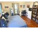 Comfortable bedroom with stylish decor, wooden floors, a dedicated desk area, and a cozy reading nook at 1031 Tony Cir, St Cloud, FL 34772