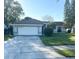 Charming single-story home with a well-maintained lawn, mature trees, and an attached two-car garage at 1031 Tony Cir, St Cloud, FL 34772