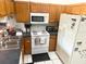 A kitchen is equipped with white appliances, wooden cabinets, and dark countertops at 1031 Tony Cir, St Cloud, FL 34772