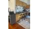 A kitchen bar area with a dark countertop, wooden cabinets, and three black bar stools at 1031 Tony Cir, St Cloud, FL 34772