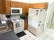A kitchen features white appliances including a stove, microwave, and refrigerator at 1031 Tony Cir, St Cloud, FL 34772