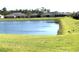 Community pond surrounded by a grassy field at 1077 Chelan Falls N Trl, Deland, FL 32724