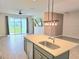 View of the open concept living space from the kitchen, highlighted by an eat-in kitchen island at 1077 Chelan Falls N Trl, Deland, FL 32724
