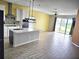 Open kitchen concept with stainless appliances, island, and a view of the backyard through sliding glass doors at 1077 Chelan Falls N Trl, Deland, FL 32724