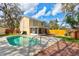 Backyard pool with a wooden deck, patio, and two-story yellow house at 1118 Meditation Loop, Port Orange, FL 32129