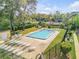 Community pool featuring sun loungers, mature trees, and pool rules sign at 116 Moonstone Ct, Port Orange, FL 32129