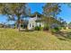 The property features a well-maintained lawn, with an outdoor living area, and lush, mature trees at 1204 Draycott St, Ormond Beach, FL 32174