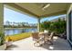 Covered patio features a ceiling fan, dining table, and a picturesque view of the lake at 1204 Draycott St, Ormond Beach, FL 32174