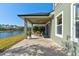 Covered patio area features outdoor dining set overlooking the serene lake view at 1204 Draycott St, Ormond Beach, FL 32174