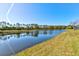 The view shows the lush landscaping and beautiful pond behind the property at 1204 Draycott St, Ormond Beach, FL 32174