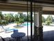 View from covered patio looking at community pool area with lush, green landscaping and blue skies at 1204 Draycott St, Ormond Beach, FL 32174