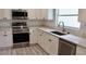 Renovated kitchen featuring white cabinetry, stainless appliances, and a modern faucet at 1275 16Th St, Orange City, FL 32763