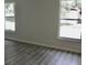 Bright living room featuring modern gray wood-look floors and windows for ample natural light at 1275 16Th St, Orange City, FL 32763