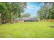 Large backyard with a screened-in pool area, green lawn, and perimeter fence at 1500 Wyngate Dr, Deland, FL 32724