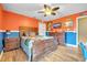 A stylish bedroom featuring wood furniture, wood-look tile floor, and a ceiling fan at 1500 Wyngate Dr, Deland, FL 32724