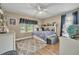 Cozy bedroom with natural light, hardwood floors, ceiling fan, and decorative rug at 1500 Wyngate Dr, Deland, FL 32724